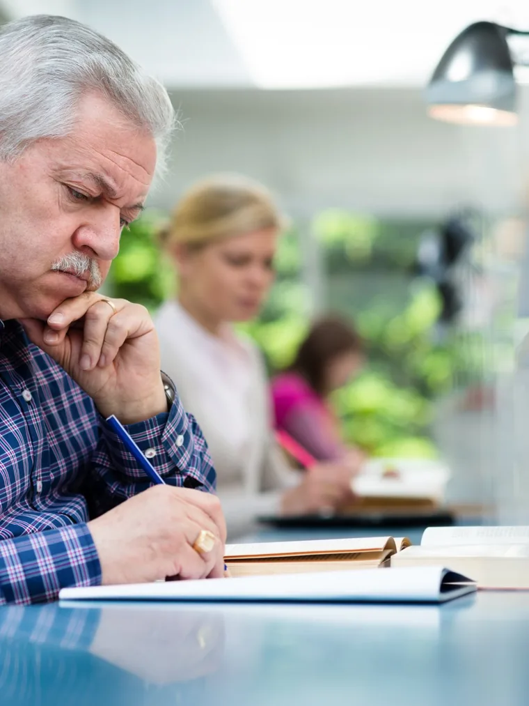 Hombre mayor estudiando en una biblioteca